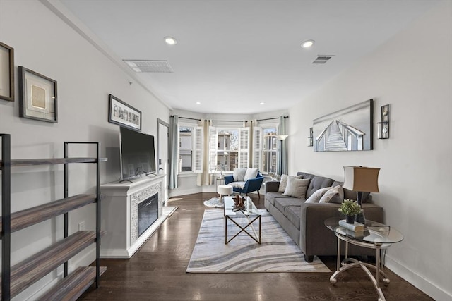 living room with visible vents, recessed lighting, baseboards, and wood finished floors