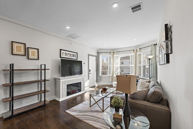 living area featuring visible vents, wood finished floors, recessed lighting, a fireplace, and baseboards