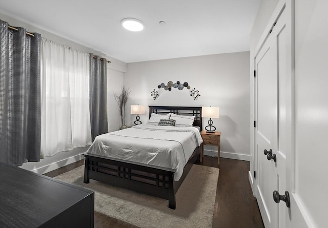 bedroom with a closet, baseboards, and wood finished floors