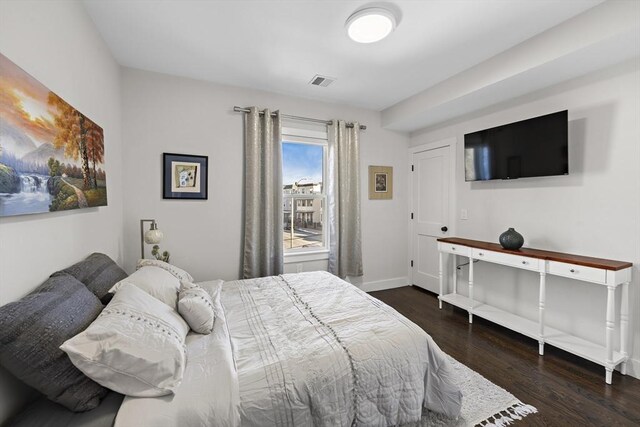 bedroom featuring visible vents, baseboards, and wood finished floors