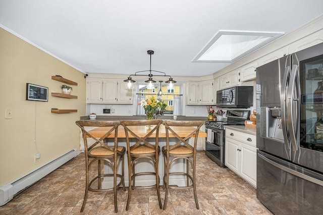 11 Florence Rd, Lowell, MA 01851 - kitchen featuring appliances with stainless steel finishes, a baseboard radiator, a kitchen breakfast bar, stone finish floors, and white cabinets