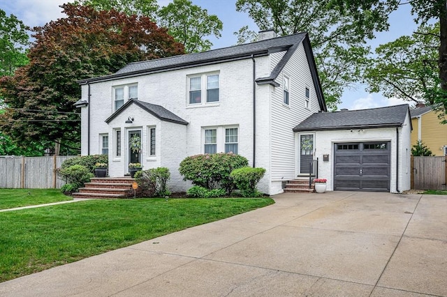 11 Florence Rd, Lowell, MA 01851 - traditional-style house featuring a garage, driveway, brick siding, and a chimney