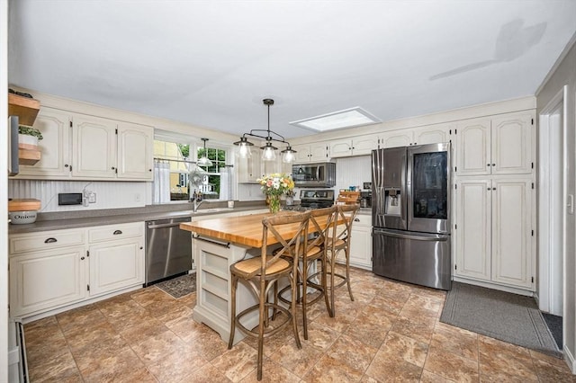 11 Florence Rd, Lowell, MA 01851 - kitchen with stainless steel appliances, butcher block countertops, stone finish flooring, and a kitchen island