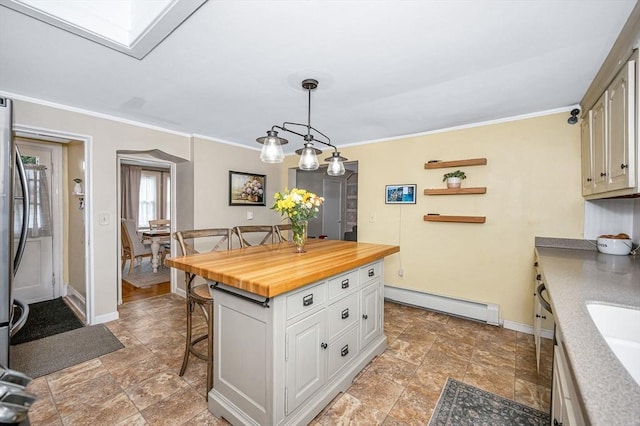 11 Florence Rd, Lowell, MA 01851 - kitchen with a baseboard heating unit, a kitchen bar, butcher block countertops, baseboards, and crown molding