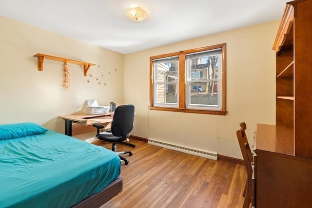 bedroom featuring light wood-type flooring, baseboards, and baseboard heating