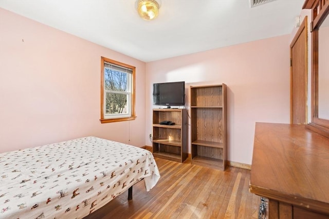 bedroom featuring light wood-style flooring and baseboards