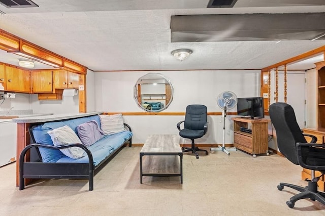 office space with a textured ceiling, light floors, visible vents, and baseboards