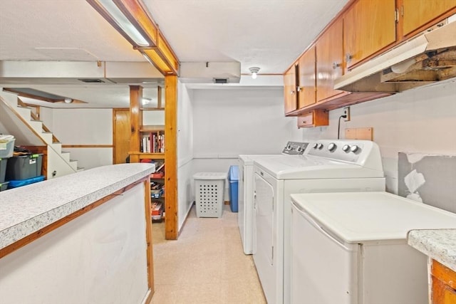 laundry area featuring cabinet space, light floors, and independent washer and dryer