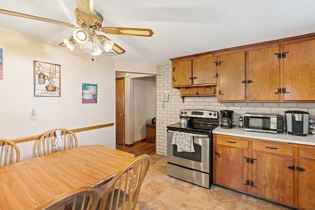 kitchen with brown cabinets, stainless steel appliances, light countertops, backsplash, and ceiling fan