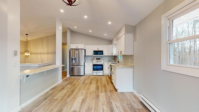 kitchen featuring decorative light fixtures, white cabinets, light stone counters, stainless steel appliances, and light wood-type flooring