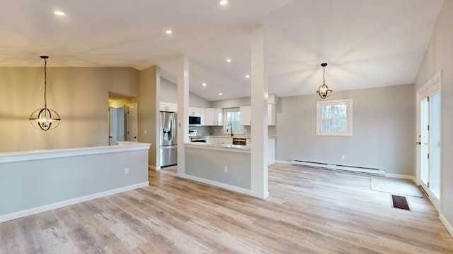 kitchen featuring stainless steel appliances, a baseboard radiator, hanging light fixtures, and white cabinets