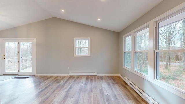 interior space with lofted ceiling, baseboard heating, and light hardwood / wood-style flooring