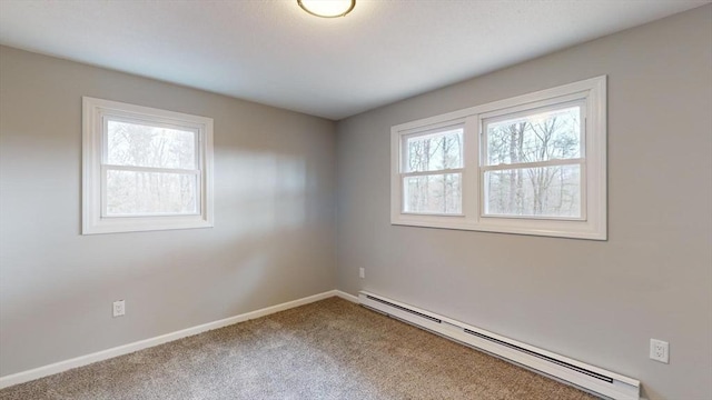 carpeted spare room featuring a healthy amount of sunlight and baseboard heating