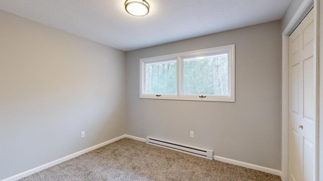 unfurnished bedroom with baseboard heating, a closet, and light carpet