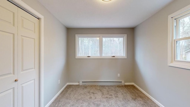 carpeted empty room with baseboard heating