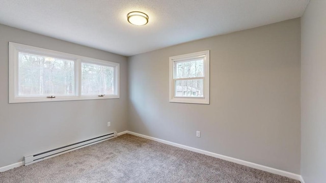 carpeted spare room with a baseboard radiator