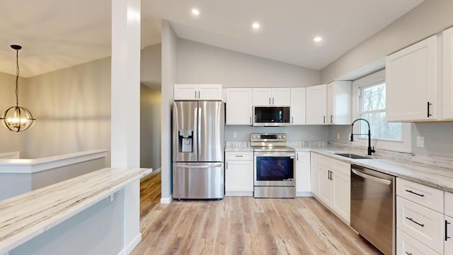 kitchen featuring appliances with stainless steel finishes, sink, hanging light fixtures, and white cabinets