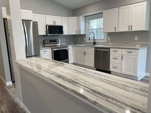 kitchen with white cabinetry, sink, stainless steel appliances, and light stone countertops