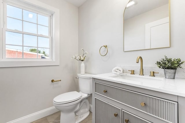 bathroom featuring tile patterned flooring, vanity, toilet, and plenty of natural light