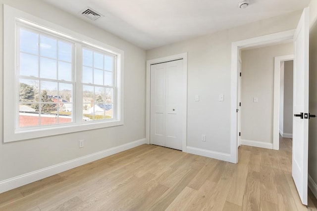 unfurnished bedroom with a closet and light hardwood / wood-style flooring