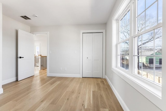 unfurnished bedroom with light wood-type flooring and a closet