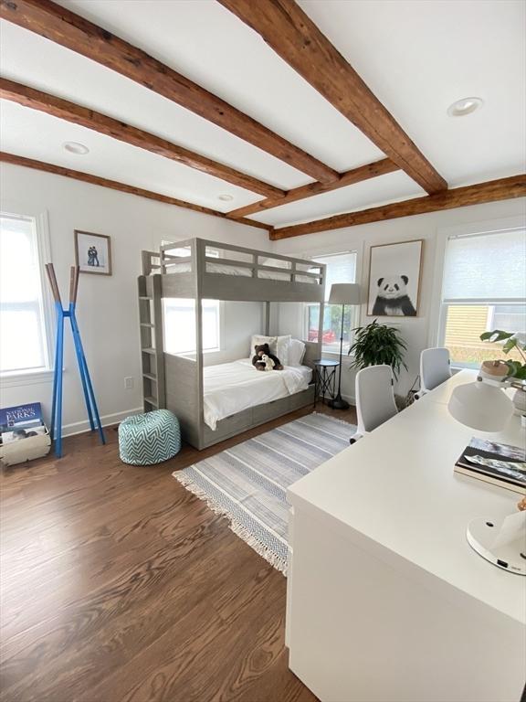 bedroom with beamed ceiling and dark wood-type flooring