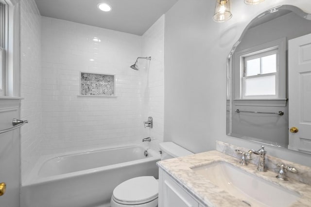 full bathroom featuring vanity, toilet, and tiled shower / bath combo