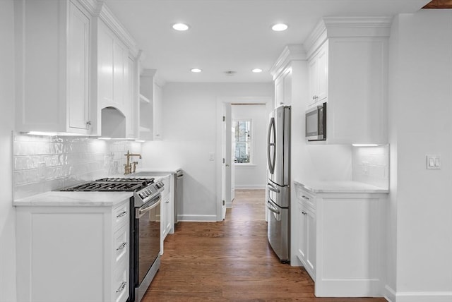 kitchen with stainless steel appliances, white cabinetry, and dark wood-type flooring