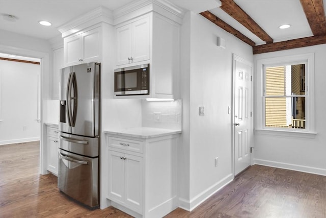 kitchen featuring tasteful backsplash, white cabinets, and appliances with stainless steel finishes