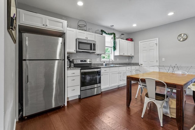 kitchen featuring sink, dark hardwood / wood-style flooring, white cabinetry, and stainless steel appliances