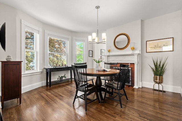 dining area featuring dark wood-style floors, baseboards, and a chandelier