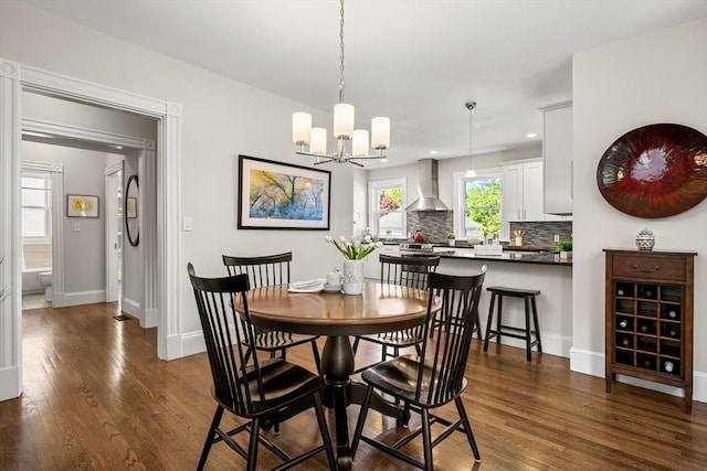 dining space with dark wood finished floors, baseboards, a chandelier, and recessed lighting