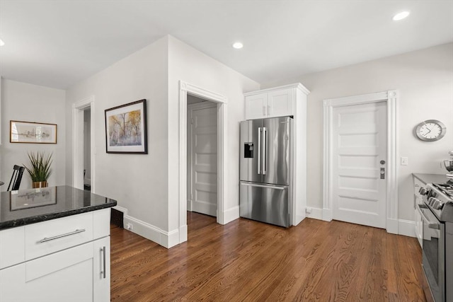 kitchen with appliances with stainless steel finishes, white cabinetry, baseboards, dark wood-style floors, and recessed lighting