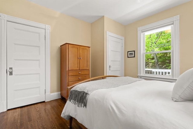 bedroom featuring dark wood-style floors and baseboards