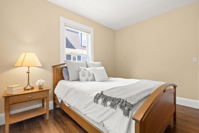 bedroom with baseboards and dark wood-type flooring