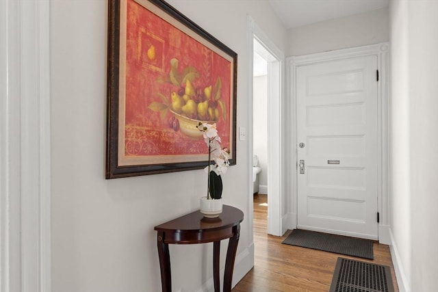 doorway to outside with wood finished floors and baseboards