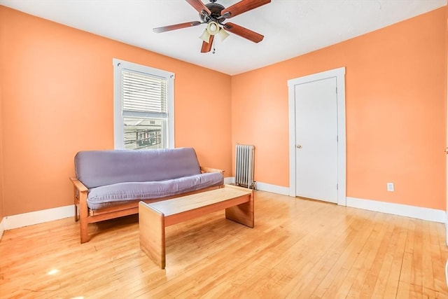 132 Myrtle St Unit 1, Waltham, MA 02453 - living area featuring radiator heating unit, light wood-type flooring, and a ceiling fan