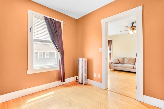 132 Myrtle St Unit 1, Waltham, MA 02453 - unfurnished room with radiator heating unit, hardwood / wood-style flooring, and a ceiling fan