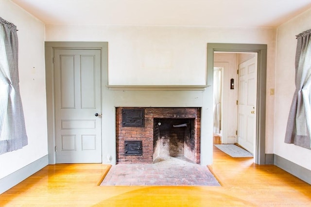 67 E Main St, West Brookfield, MA 01585 - unfurnished living room with a brick fireplace and wood finished floors