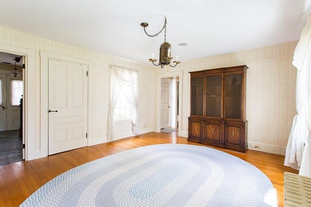 67 E Main St, West Brookfield, MA 01585 - bedroom with wallpapered walls, a chandelier, wood finished floors, and baseboards