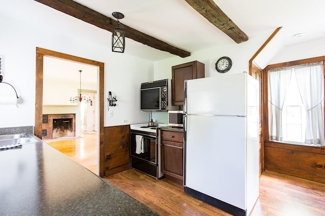 67 E Main St, West Brookfield, MA 01585 - kitchen featuring freestanding refrigerator, range with electric cooktop, wood finished floors, beamed ceiling, and a brick fireplace