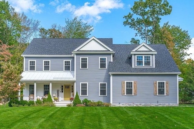 view of front of home with a shingled roof, metal roof, a porch, and a front lawn