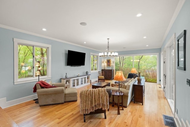 living area with light wood-type flooring, crown molding, baseboards, recessed lighting, and a chandelier