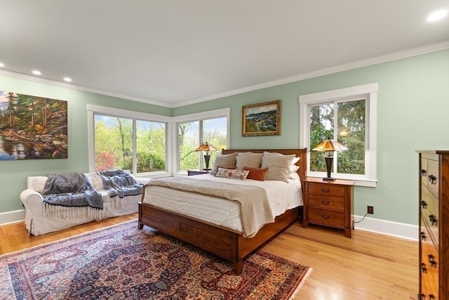 bedroom with multiple windows, crown molding, light wood finished floors, baseboards, and recessed lighting