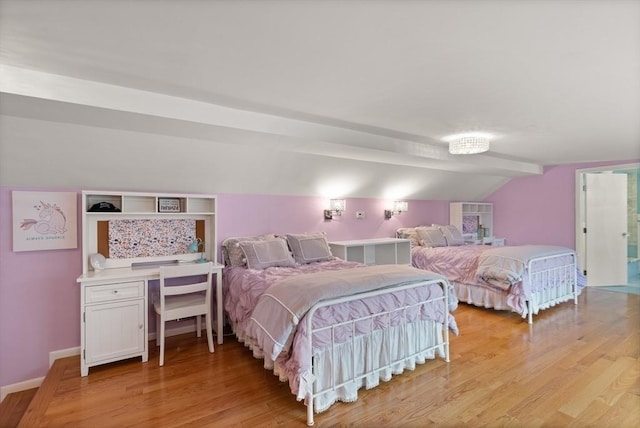 bedroom featuring lofted ceiling and light wood-style flooring