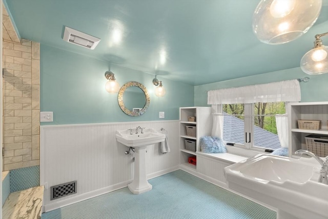 full bath with a wainscoted wall and a sink