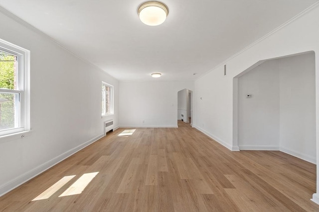 unfurnished room with light wood-type flooring, baseboards, and crown molding