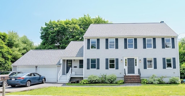 575 E St, Mansfield, MA 02048 - colonial inspired home featuring a garage, a front yard, and asphalt driveway