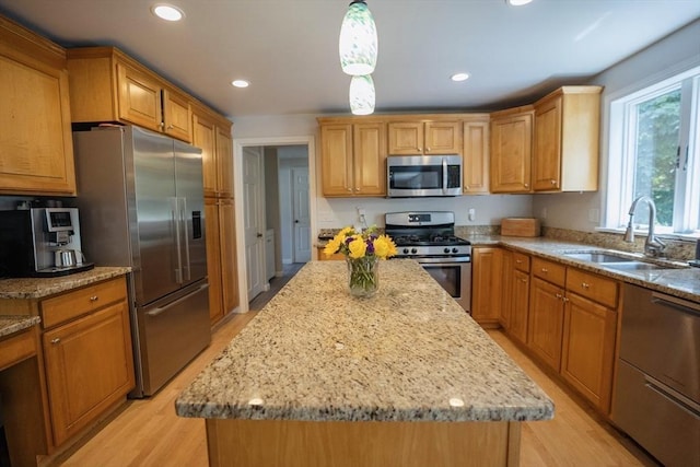 575 E St, Mansfield, MA 02048 - kitchen featuring appliances with stainless steel finishes, light wood-style floors, light stone counters, a center island, and recessed lighting