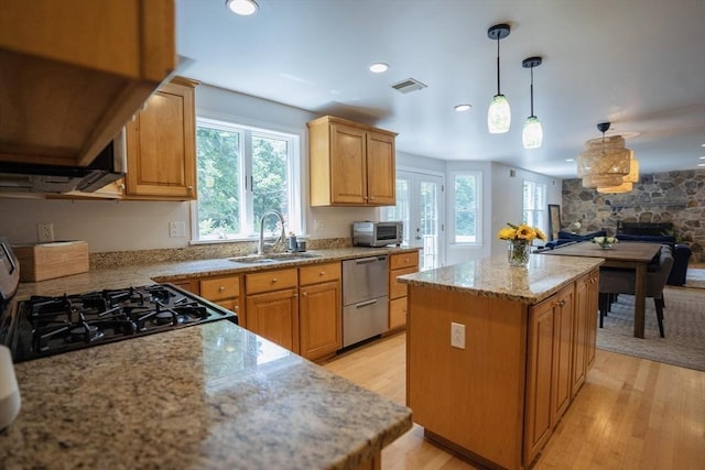 575 E St, Mansfield, MA 02048 - kitchen featuring dishwasher, a kitchen island, light wood-style flooring, a stone fireplace, and hanging light fixtures